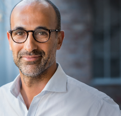 Man with glasses smiling.