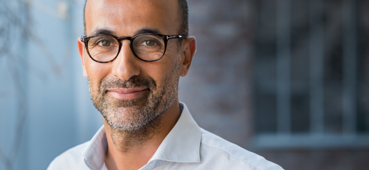 Man with glasses smiling.