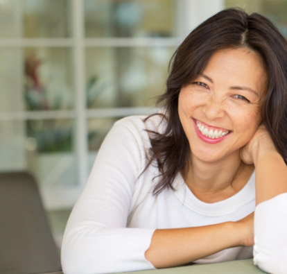 Woman with a white blouse, smiling.