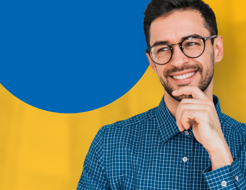 Man smiling in a blue checkered button up shirt smiling.