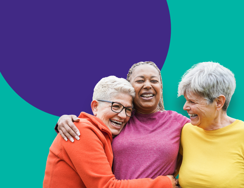 Three woman hugging and lauging.