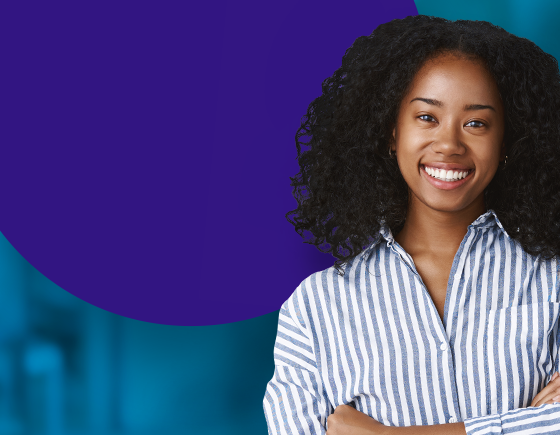 Woman similing with a blue and white stripped button up shirt.