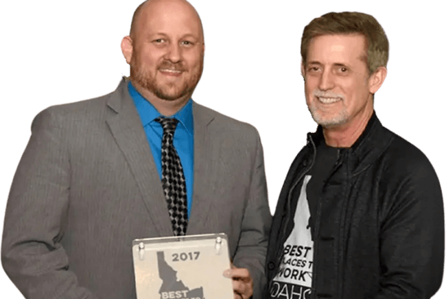 Two Moneytree employees smiling with a 2017 Best Places to Work in Idaho award plaque.