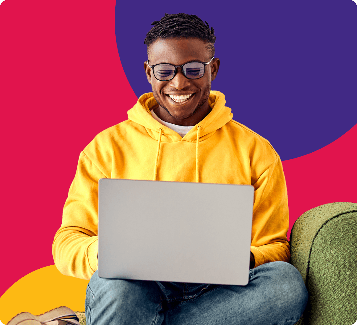 Smiling man in yellow hoodie using laptop, representing Moneytree’s accessible and modern financial services.