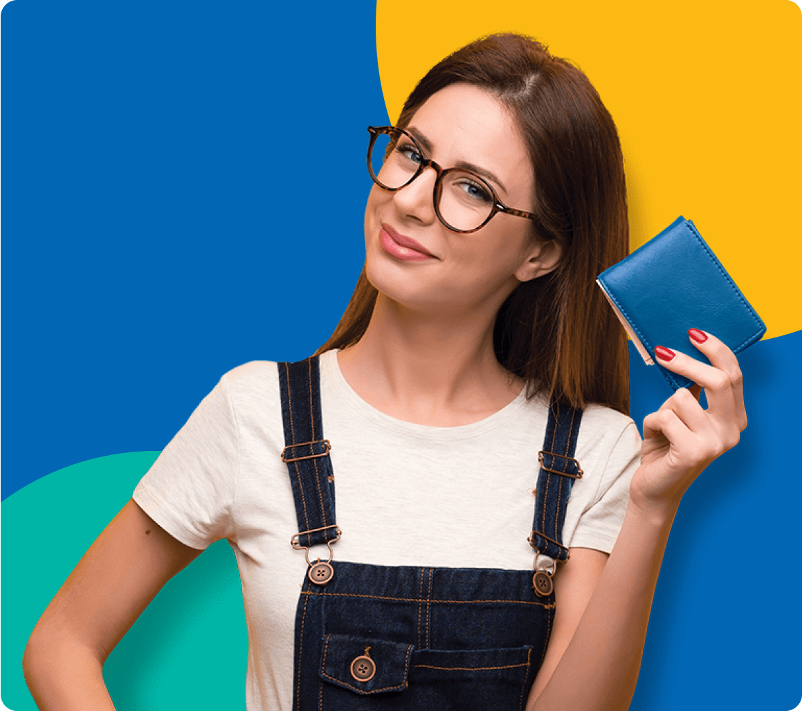 Woman in overalls holding a wallet and smiling.