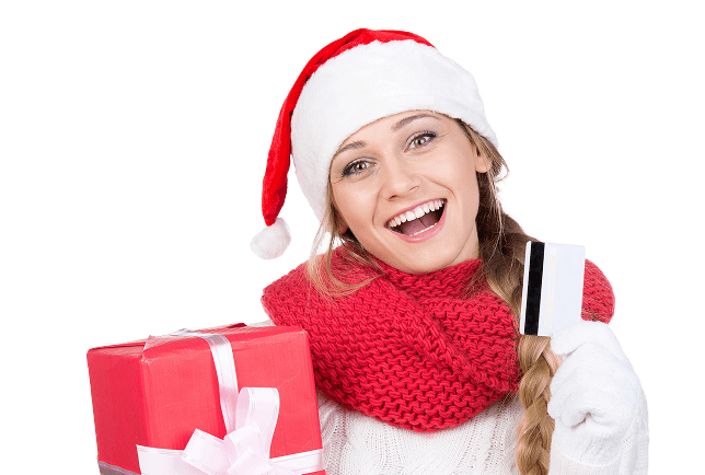 Happy woman in holiday attire holding gift and card.
